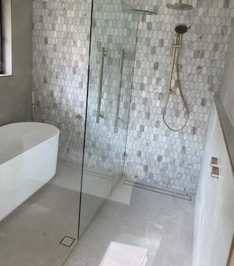 Marble-look mosaic shower with brushed brass fittings