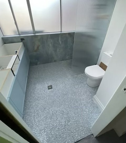 Bathroom with mosaic floor and fluted glass