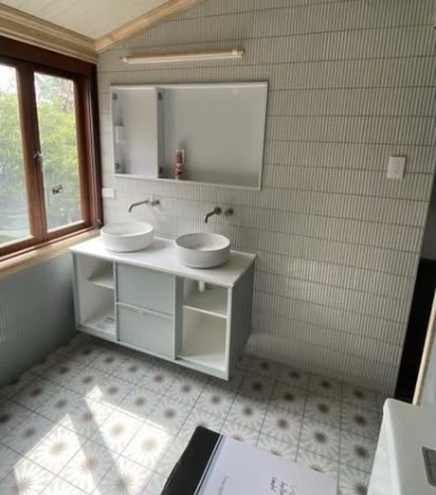 Bathroom with double vessel basins and patterned floor tiles