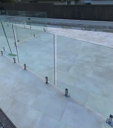 Large-format tiles on an outdoor terrace with glass balustrade