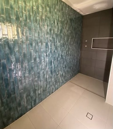 Gloss green handmade-look tiles on a feature wall
